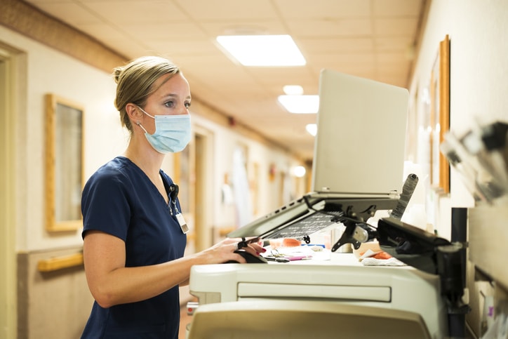 nurse using laptop wearing mask